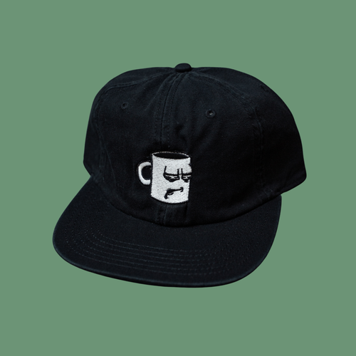 A black and white hat from with an embroidered logo from Tired Eyes Coffee.