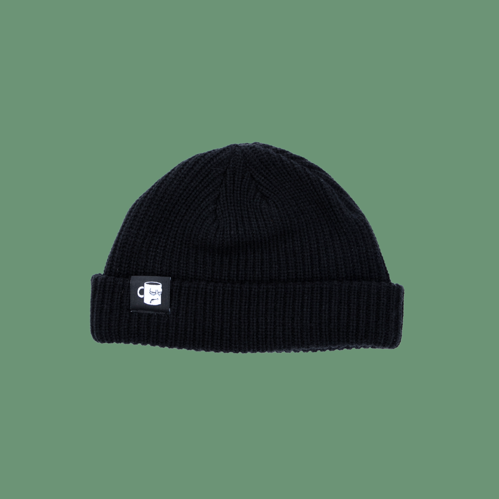 A black and white knit beanie from with an embroidered logo from Tired Eyes Coffee.
