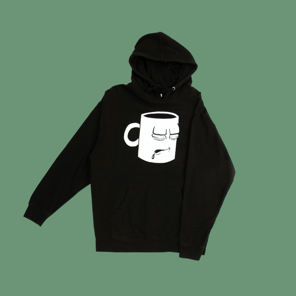 A Tired Eyes Coffee Classic Mug Hoodie with a white print on black hoodie.